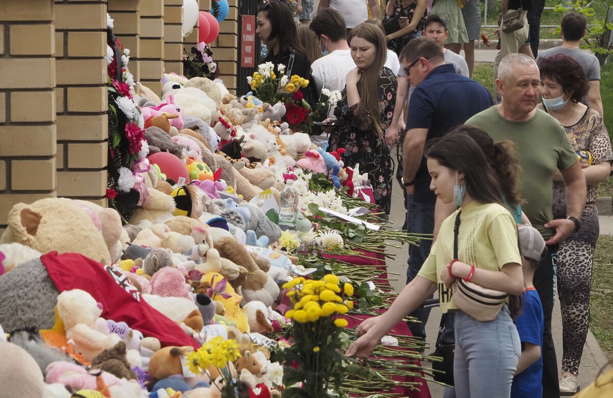 People lay flowers and toys near a school after a shooting on Tuesday in Kazan, Russia, Thursday, May 13, 2021. Russian officials say a gunman attacked a school in the city of Kazan and Russian officials say several people have been killed. Officials said the dead in Tuesday's shooting include students, a teacher and a school worker. Authorities also say over 20 others have been hospitalised with wounds. (AP Photo/Dmitri Lovetsky)