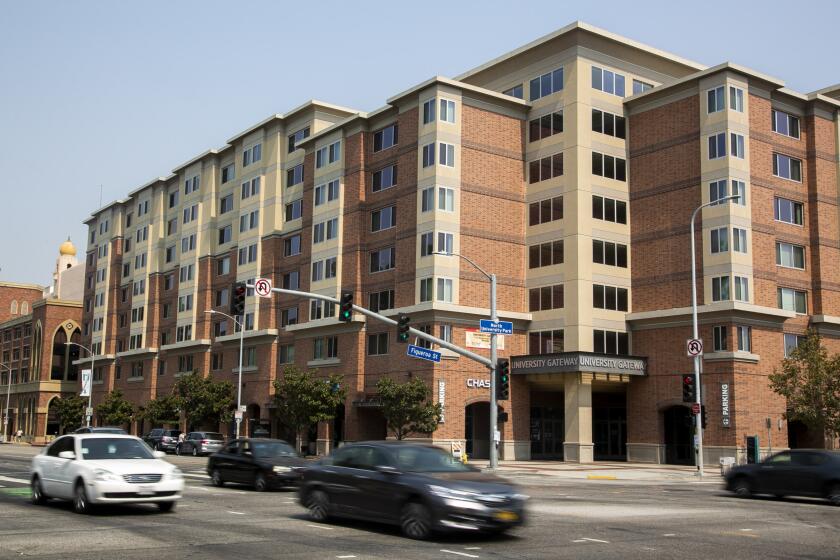 LOS ANGELES, CA - AUGUST 20: Cars pass by University Gateway Apartments on Thursday, Aug. 20, 2020 in Los Angeles, CA. University Gateway has a reputation as a party location and that hasn't changed despite coronavirus.(Josie Norris / Los Angeles Times)