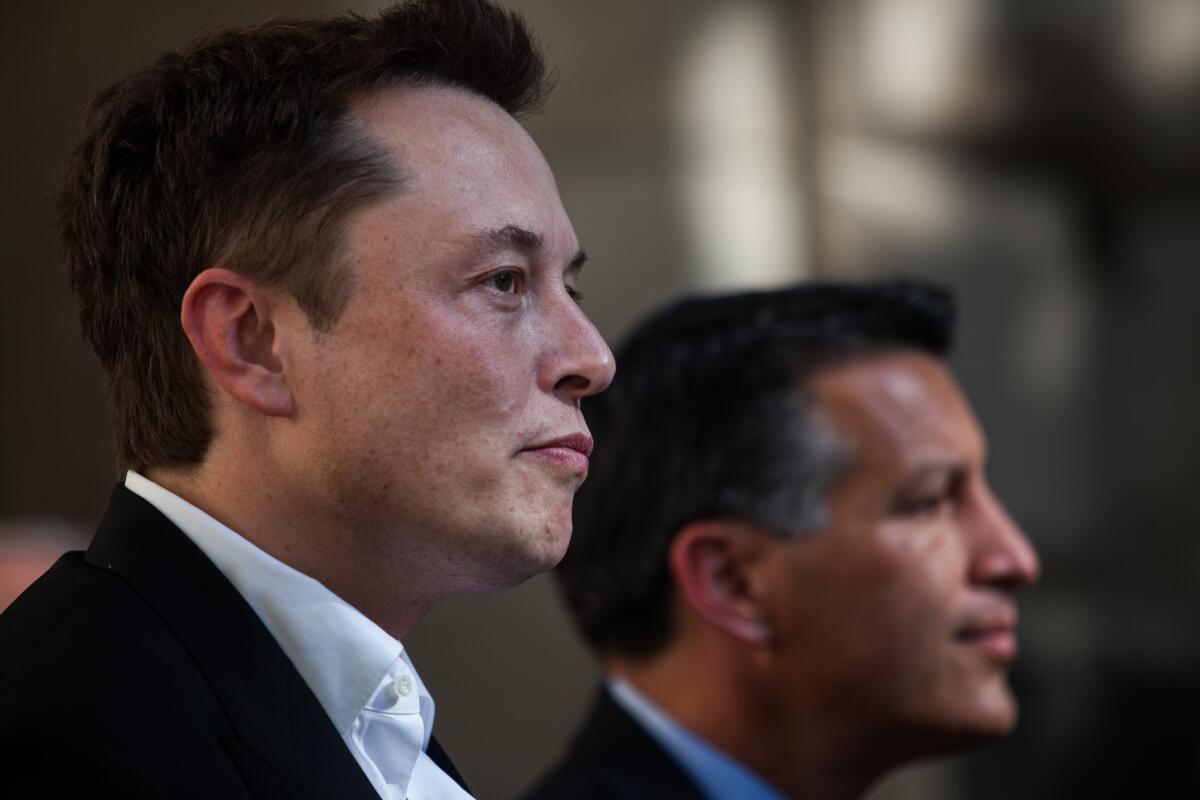 Tesla Motors CEO Elon Musk, left, and Nevada Gov. Brian Sandoval announce plans to build a battery factory in the Reno-Sparks area during a news conference at the Capitol in Carson City.
