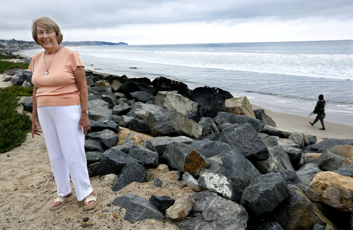 Wini Lumsden of Broad Beach, Malibu, stands next to a rock revetment designed to protect her home from water damage. A sand replenishment project will create 50 to 60 feet of restored dune over the revetment and 60 to 70 feet of restored beach.