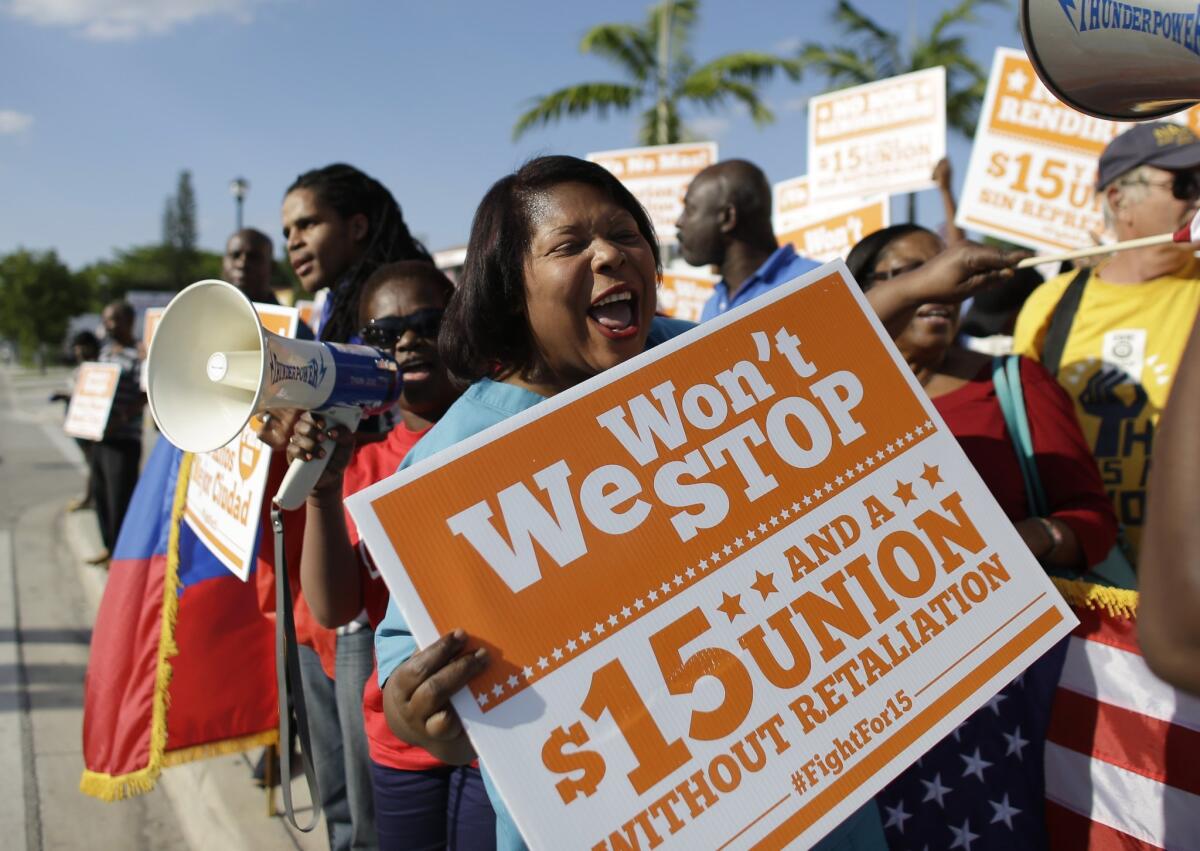 Participants chant slogans during a May 1 protest in Miami in support of a $15 per hour minimum wage and access to healthcare.