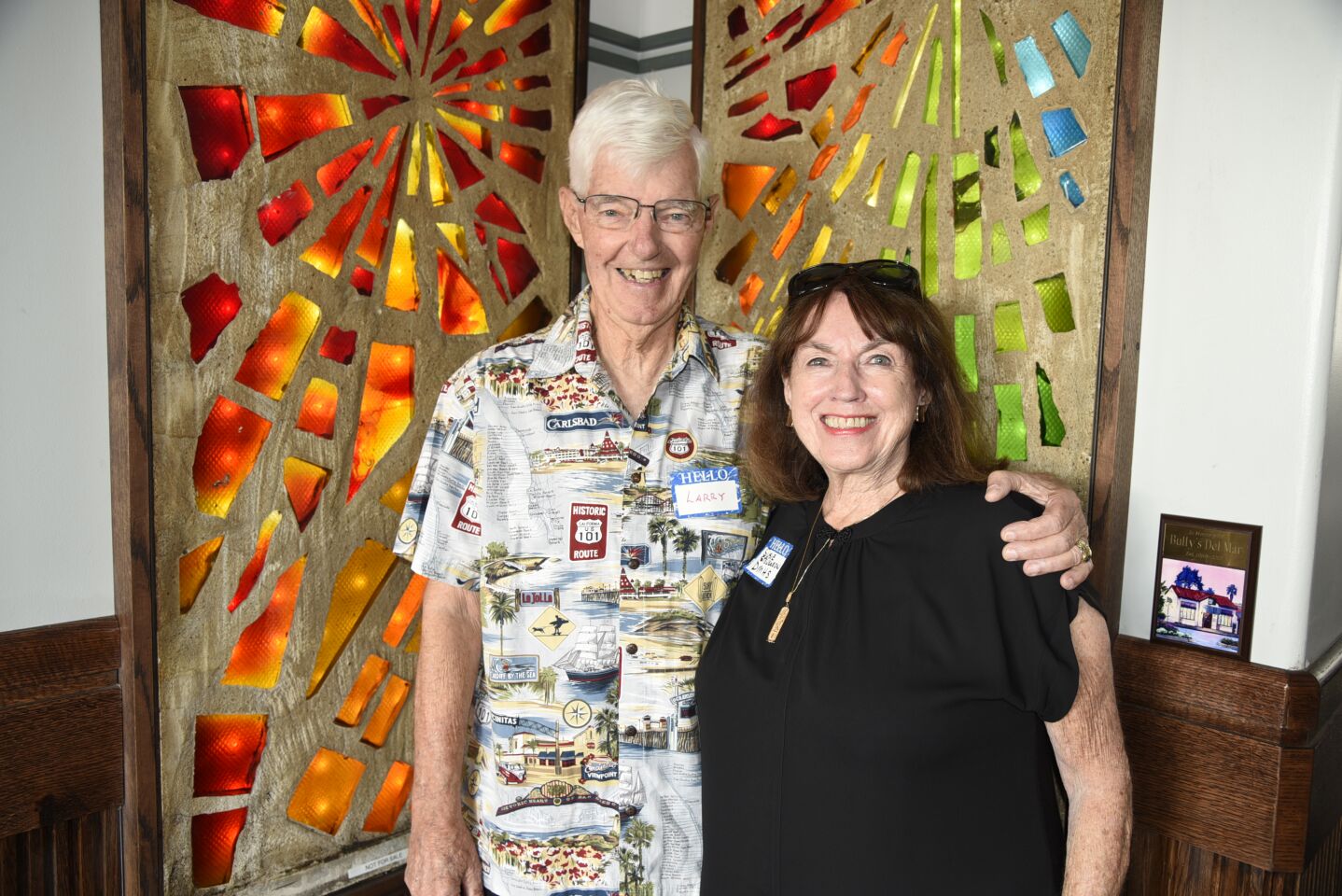 DMHS President Larry Brooks and Susie Stevenson with some of the stained-glass windows from Bullys