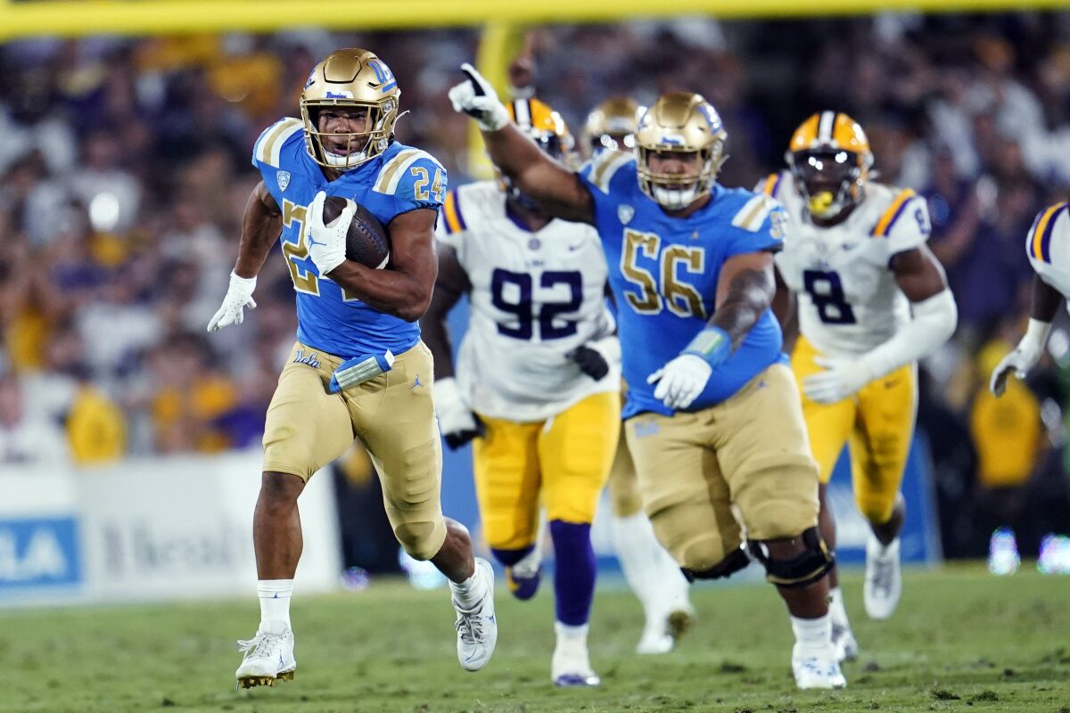 UCLA running back Zach Charbonnet, left, carries against LSU during the second half of an NCAA college football game Saturday, Sept. 4, 2021, in Pasadena, Calif. (AP Photo/Marcio Jose Sanchez)