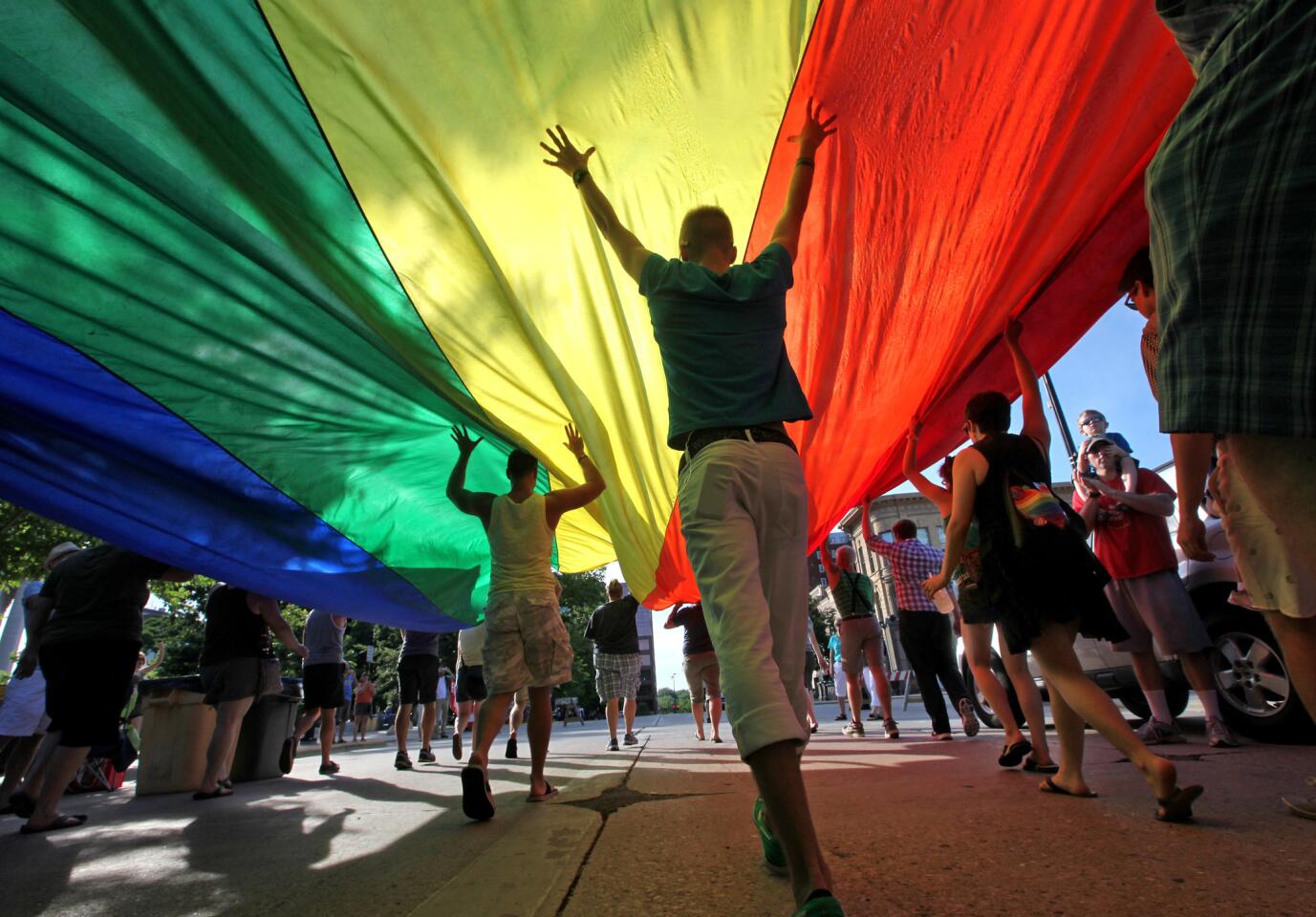 Supporters of a U.S. Supreme Court ruling which overturned the federal Defense of Marriage Act carry a large rainbow flag during a parade around the Wisconsin State Capitol in June, 2013.