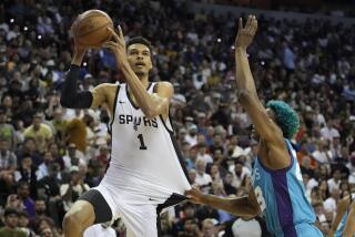 San Antonio Spurs' Victor Wembanyama shoots over Charlotte Hornets' Kai Jones during the first half of an NBA summer league basketball game Friday, July 7, 2023, in Las Vegas. (AP Photo/John Locher)