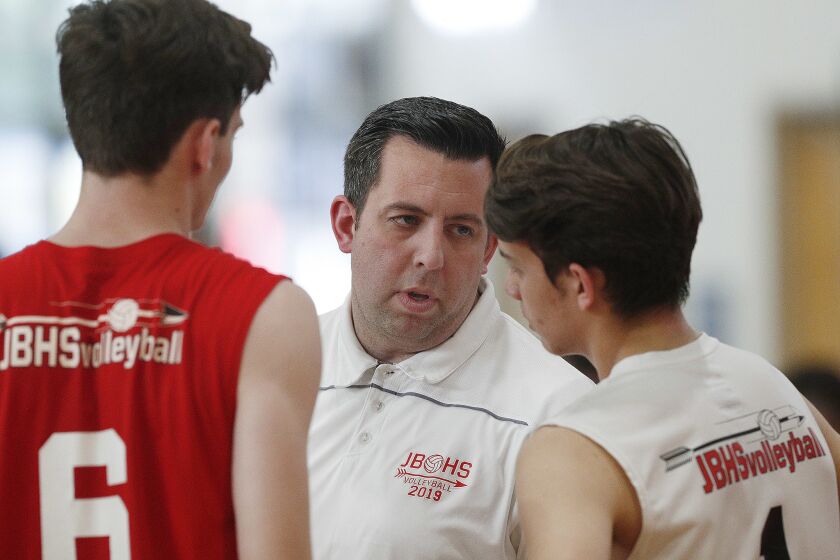 Burroughs' head coach Joel Brinton talks with players Connor Burroughs and Sam Tipton before the start of the match against Burbank in a Pacific League boys' volleyball match at Burroughs High School on Tuesday, April 23, 2019. Burroughs won the match 3-0.