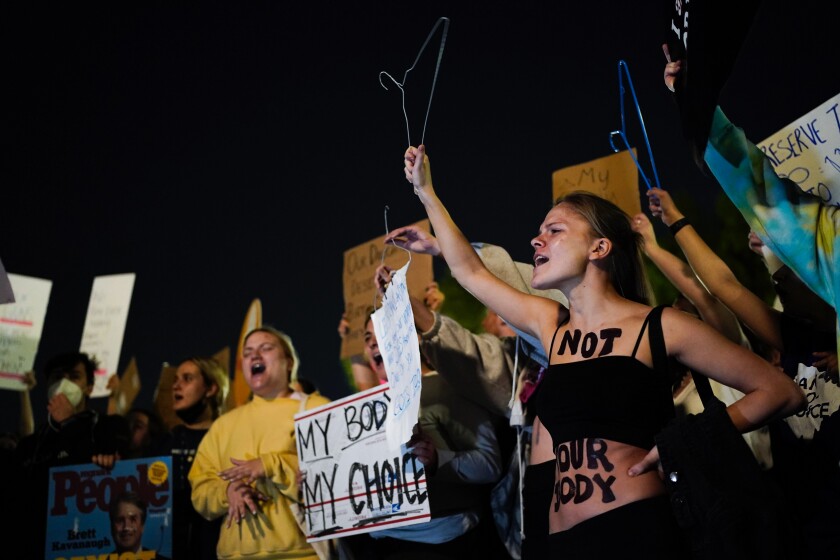 A crowd gathers outside the Supreme Court on Monday night .