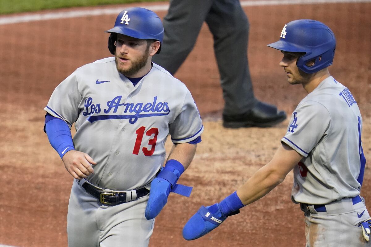 Max Muncy and Trea Turner return to the dugout after scoring on a double.