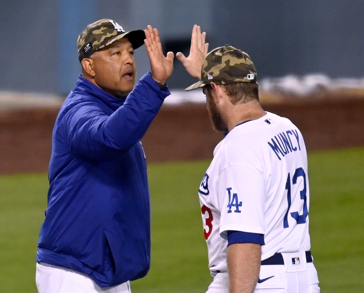 Dodgers manager Dave Roberts, left, high-fives with first baseman Max Muncy.