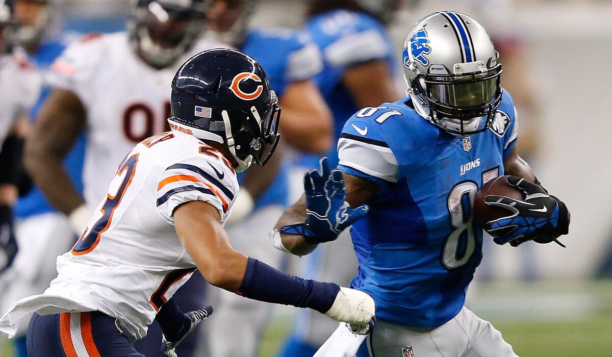 Bears cornerback Kyle Fuller looks to tackle Lions wide receiver Calvin Johnson, who scored two touchdowns in the first half Thursday in Detroit.
