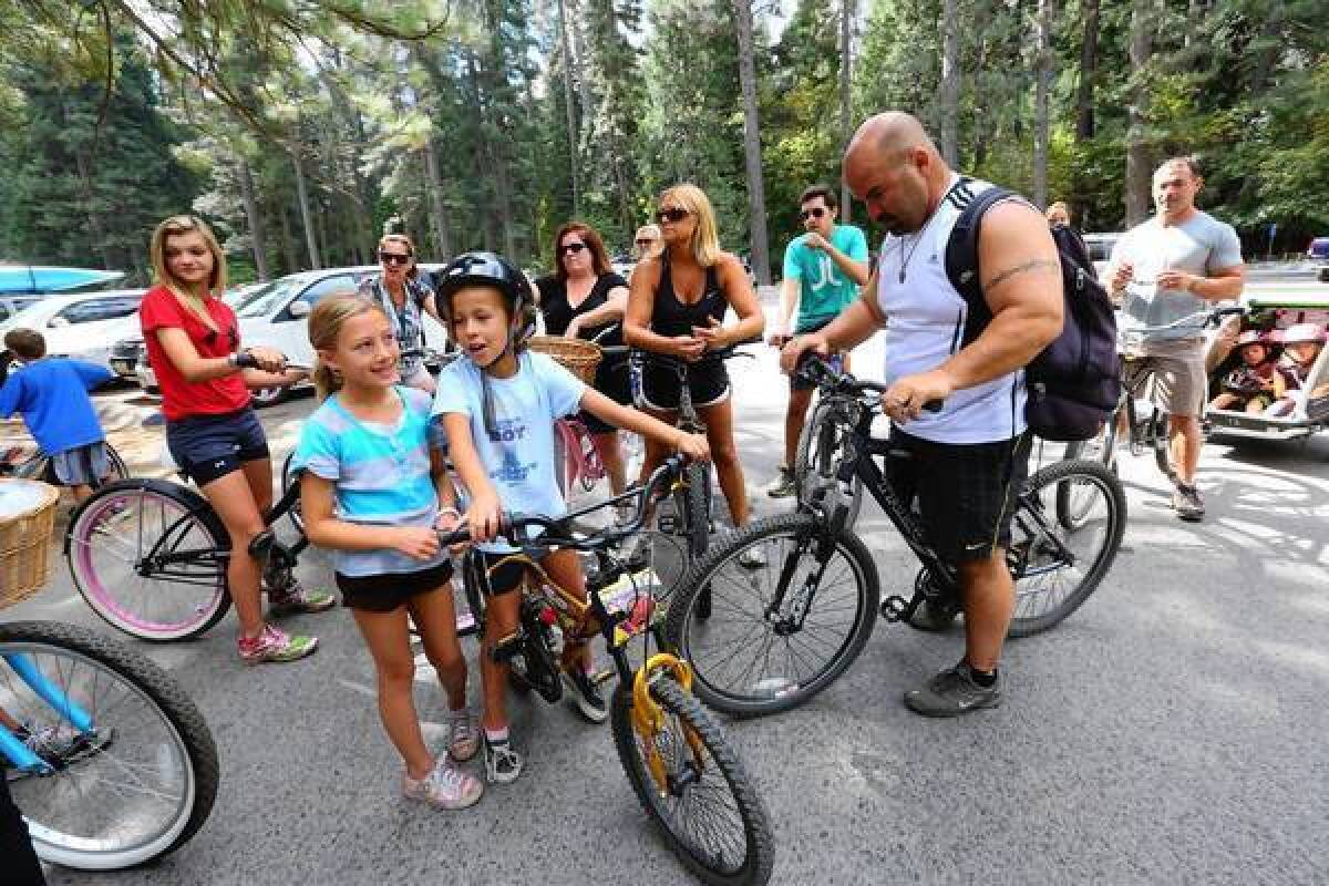 A group of families from San Jose gets ready for a bike ride in Curry Village at Yosemite National Park. The number of daily visitors would not be reduced under a National Park Service overhaul plan.