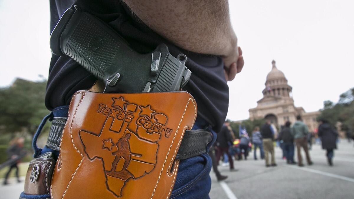 Terry Holcomb, Executive Director of Texas Carry displays his customized holster as he walks to the State Capitol for a rally in Austin, Tx. on Jan. 1, 2016.
