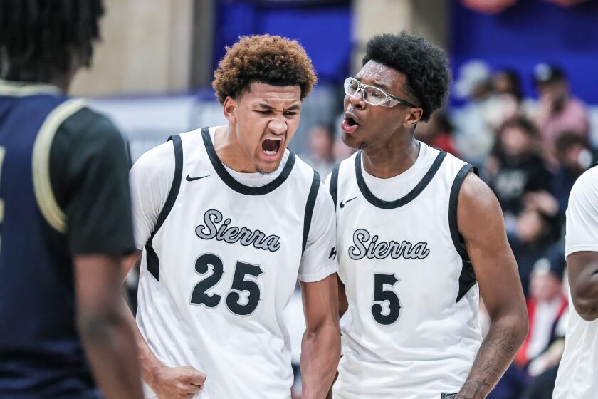 Maximo Adams (left) gets fired up after basket and receives encouragement from Sierra Canyon teammate Bryce James.