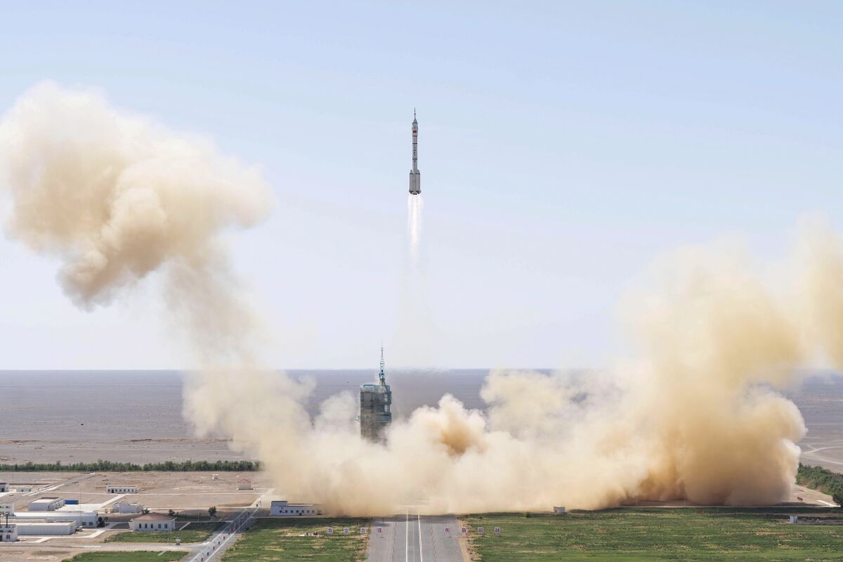 In this photo released by Xinhua News Agency, the Long March-2F carrier rocket carrying China's Shenzhou 14 spacecraft blasts off from the launch pad at the Jiuquan Satellite Launch Center in Jiuquan, northwest China's Gansu Province, Sunday, June 5, 2022. China on Sunday launched the new three-person mission to complete work on its permanent orbiting space station. (Cai Yang/Xinhua via AP)