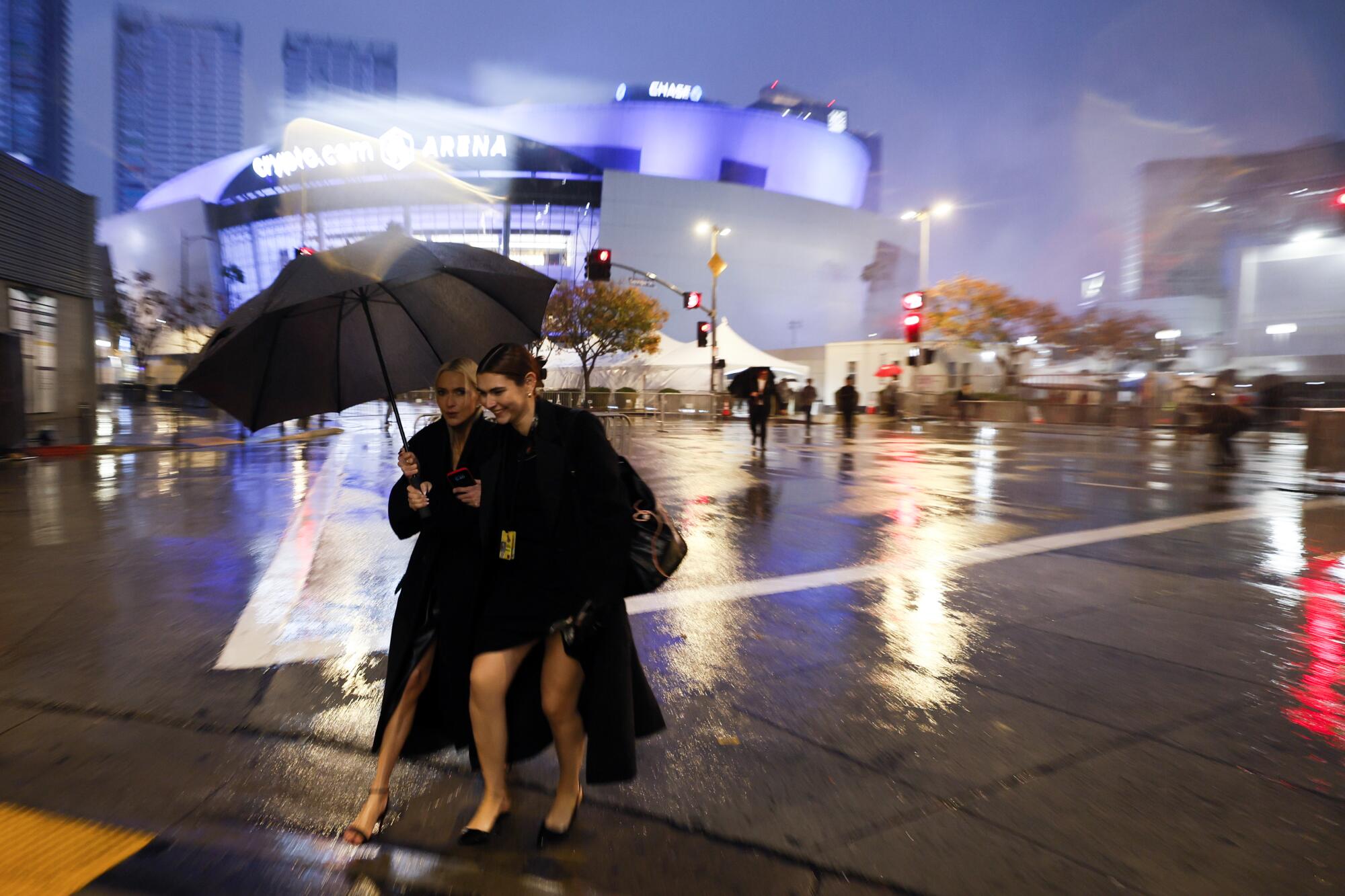People attending the Grammys run between the red carpet and a parking garage as another storm bears down.