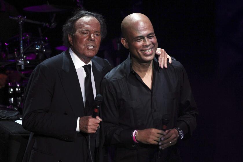Julio Iglesias, left, is joined onstage by former singer and current president of Haiti Michel Martelly during a charity concert in the Dominican Republic last December.