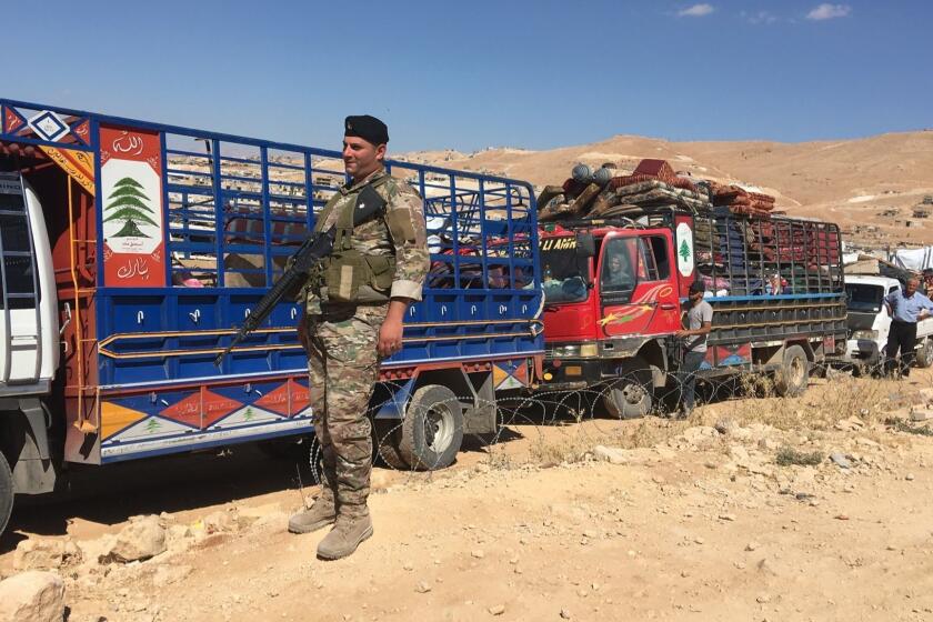 Members of the Lebanese armed forces watch over departing Syrian refugees at a checkpoint on the edge of the Lebanese border down of Arsal on July 23, 2018. Now that the Syrian army, backed by its allies Russia and Iran, has taken back large swathes of territory from rebels, the Lebanese security forces and their Syrian counterparts have started organizing the repatriation refugees.