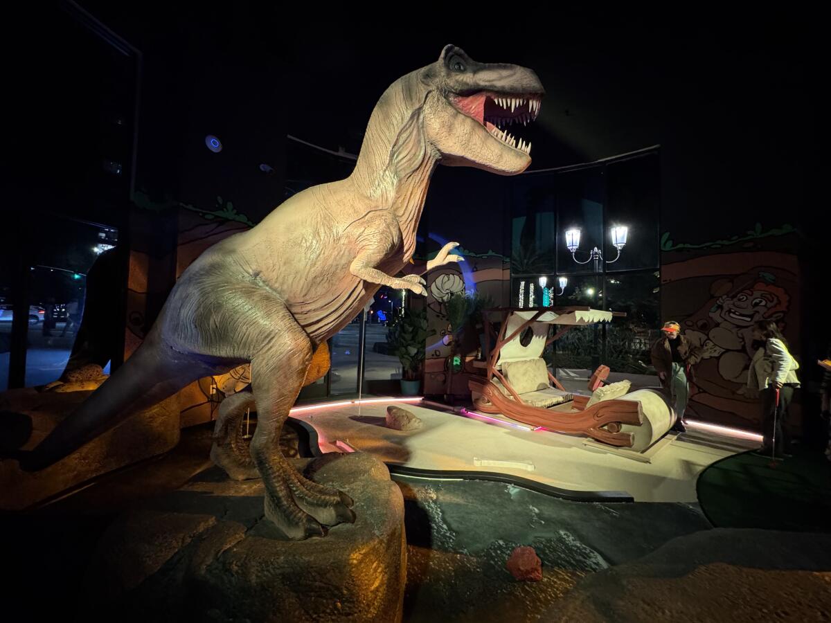 Os cenários em Holey Moley são variados e detalhados, incluindo este dinossauro.