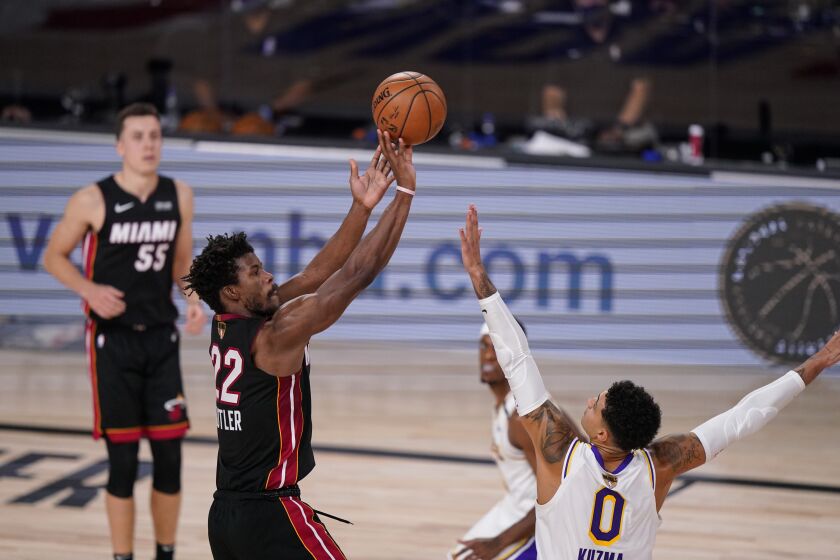 Miami Heat's Jimmy Butler (22) shoots against Los Angeles Lakers' Kyle Kuzma (0) during the second half in Game 3 of basketball's NBA Finals, Sunday, Oct. 4, 2020, in Lake Buena Vista, Fla. (AP Photo/Mark J. Terrill)