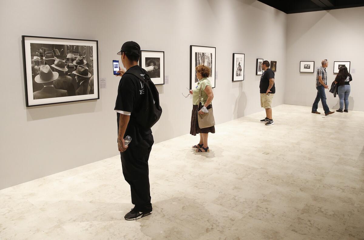 Guests view photographs at "The Power of Photography" at the Bower's Museum.