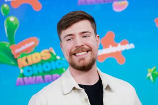 MrBeast smiling and wearing a cream-colored jacket and a black shirt