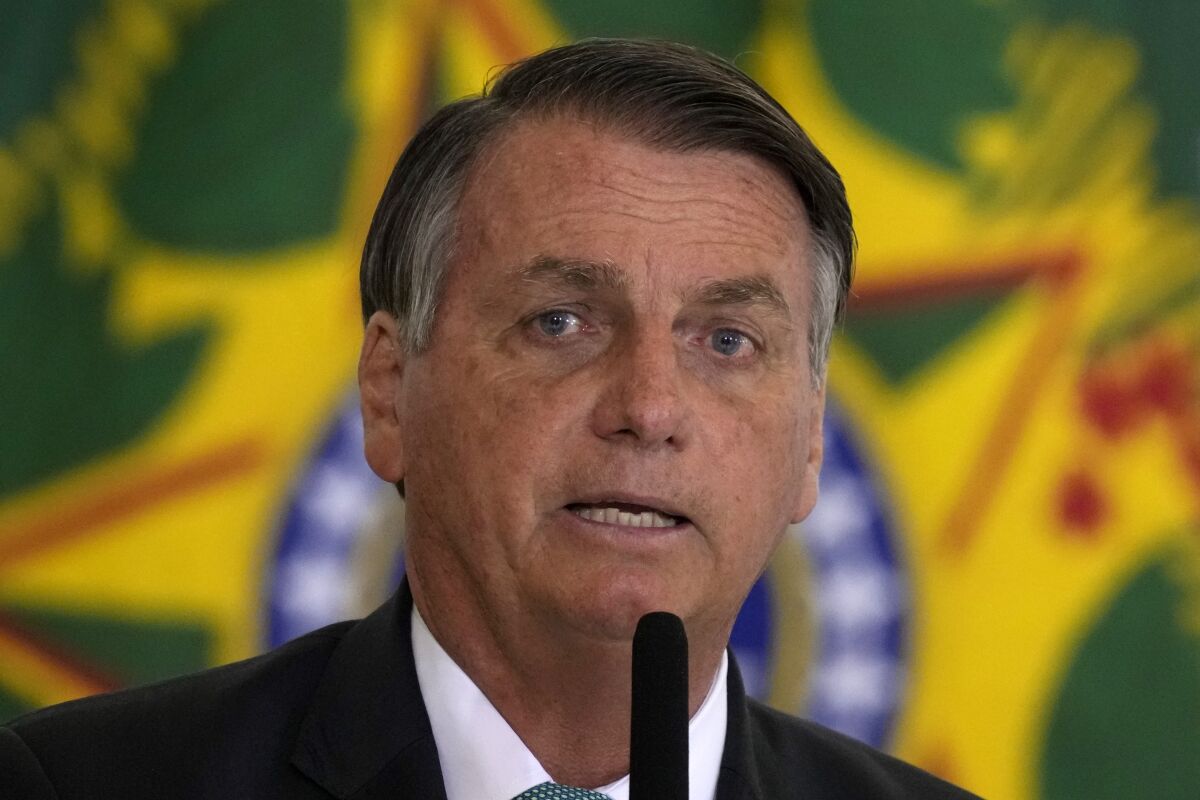 FILE - In this Sept. 15, 2021 file photo, Brazilian President Jair Bolsonaro attends a housing program launch ceremony at the Planalto presidential palace, in Brasilia, Brazil. A group of climate lawyers called Tuesday, Oct. 12, 2021 for the International Criminal Court to launch an investigation into Brazil's president for possible crimes against humanity for his administration's Amazon policies. (AP Photo/Eraldo Peres, file)
