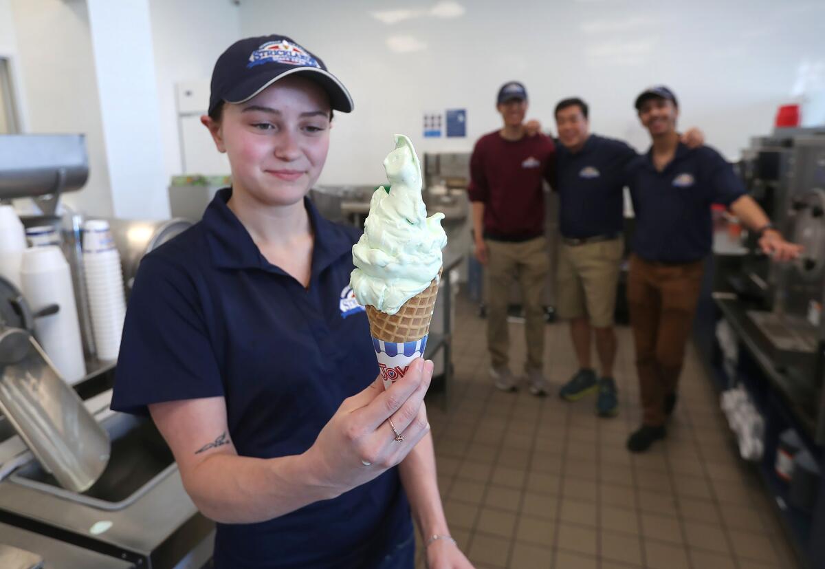 Emplyee Amber Markham holds a Strickand pistachio-flavored ice cream in a waffle cone.