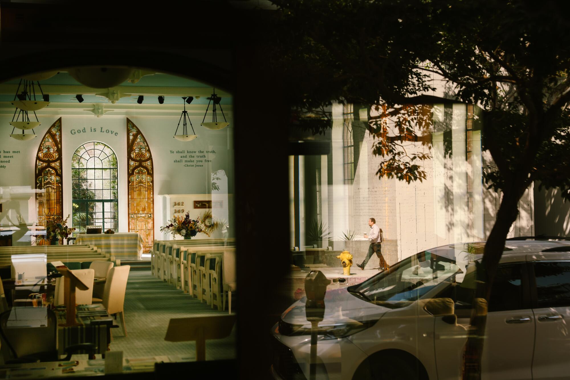 A passerby is seen in the reflection of the Third Church of Christ, Scientist of Los Angeles.