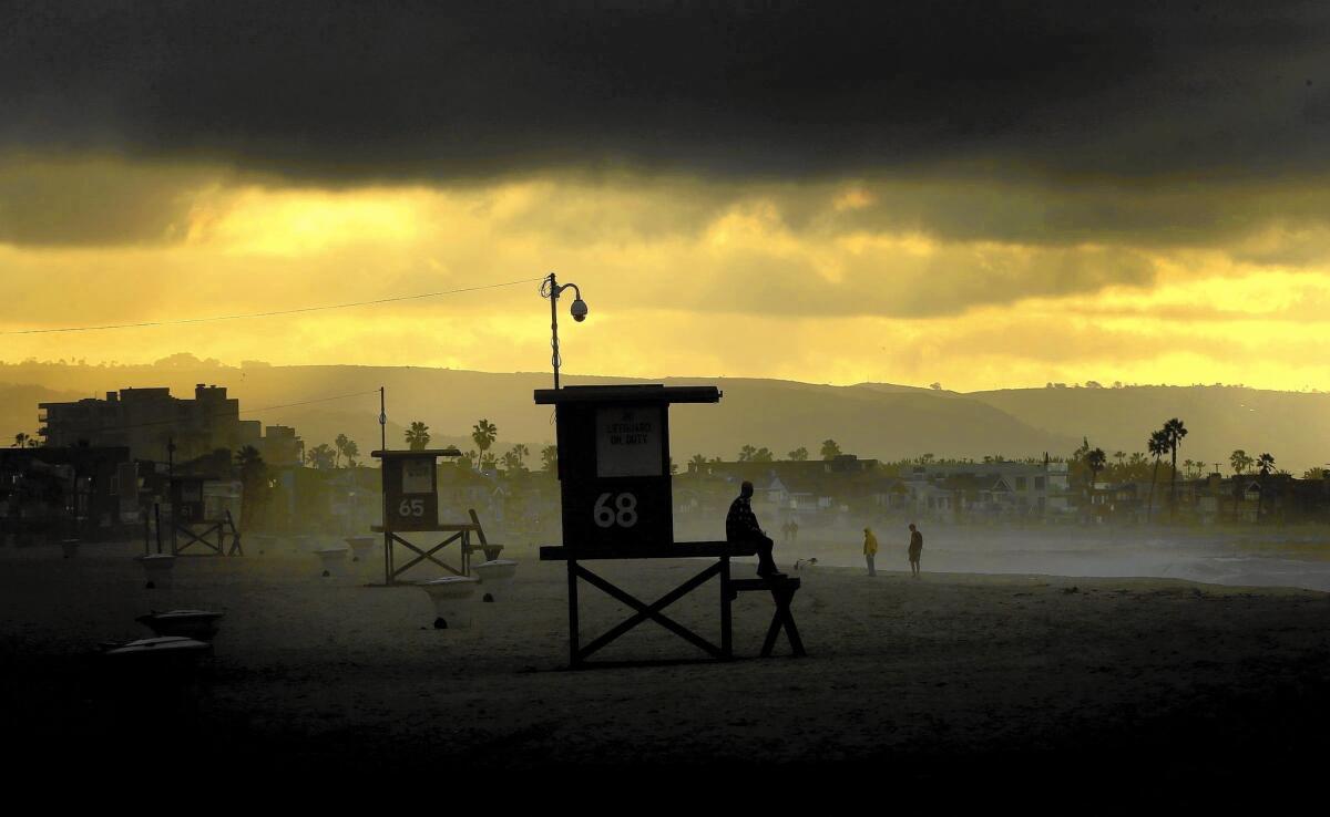 Storm clouds linger in Newport Beach after two days of rain. Scientists differ on exact measurements, but agree that the state has a long way to go to get out of the drought.