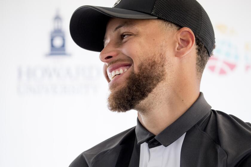 The Howard University logo is visible behind Golden State Warriors guard Stephen Curry as he appears at a news conference at Langston Golf Course in Washington, Monday, Aug. 19, 2019, where Curry announced that he would be sponsoring the creation of men's and women's golf teams at Howard University. (AP Photo/Andrew Harnik)