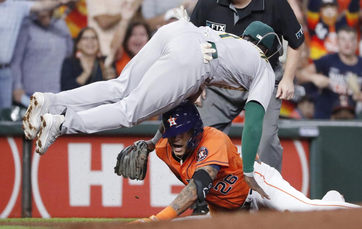 Oakland Athletics third baseman Josh Harrison is upended by Houston Astros Jose Siri sliding in on a triple during the first inning of a baseball game Friday, Oct. 1, 2021 at Minute Maid Park in Houston. (Kevin M. Cox/The Galveston County Daily News via AP)
