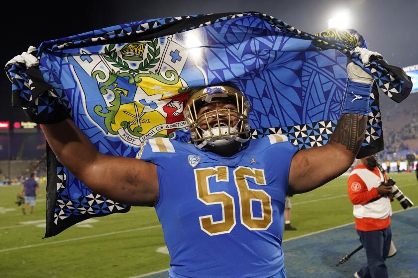 UCLA offensive lineman Atonio Mafi waves a flag as he celebrates the team's win over LSU.