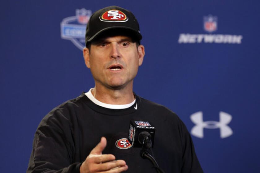 San Francisco 49ers Coach Jim Harbaugh answers questions during a news conference at the NFL scouting combine in Indianapolis on Thursday.