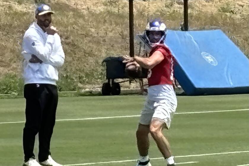 Rams quarterback Stetson Bennett goes through drills during an organized team activity workout as quarterbacks coach Dave Ragone watches.