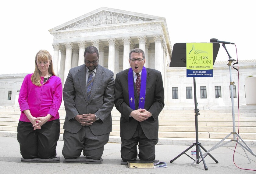 Activists pray in front of the Supreme Court after justices cleared the way for local officials to open public meetings with explicitly Christian prayers.