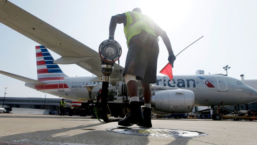 A worker finishes fueling an American Airlines jet at Dallas/Fort Worth International Airport. Expected higher fuel costs this year could create turbulence for the nation's airline industry.