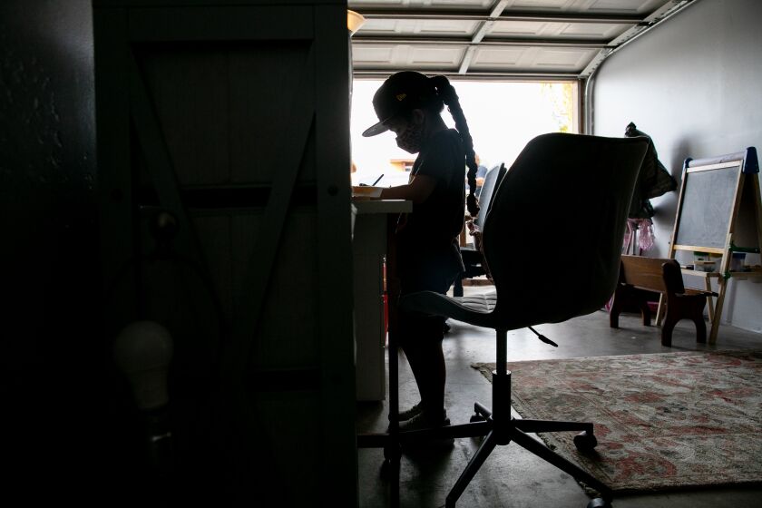 SAN DIEGO, CA - OCTOBER 23: Zoey Castillo, 5, takes part in distance learning alongside her mother, Karla Ramirez, in their garage in City Heights on Friday, Oct. 23, 2020 in San Diego, CA. (Sam Hodgson / The San Diego Union-Tribune)