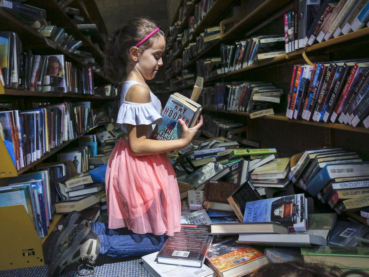Zoe Pineda, 7, helps clean up the library in Ridgecrest after the Fourth of July quake.