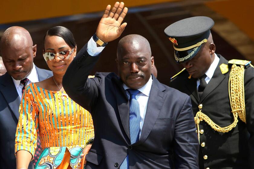 Congolese President Joseph Kabila waves as he and others celebrate independence day for the Democratic Republic of Congo in Kindu on June 30, 2016.