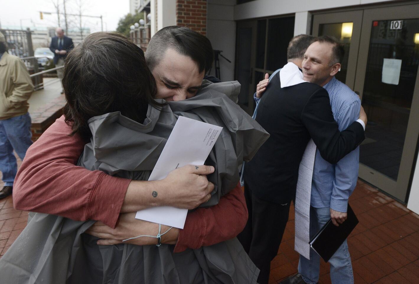 Justin Morgan, left, and Glenn Cannon, right, hug supporters after getting their marriage license in Montgomery, Ala.