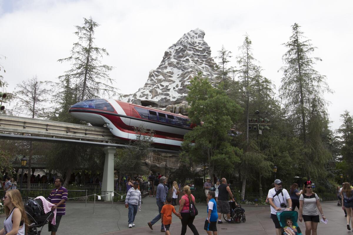 Disneyland Monorail passes by the Matterhorn Bobsled ride in the background at Disneyland during its 60th Anniversary Diamond Jubilee.
