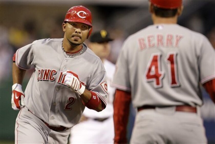 Cincinnati Reds' Alex Gonzalez (2) rounds third to greetings from coach Mark Berry (41) after hitting a fourth-inning three-run homer off Pittsburgh Pirates pitcher Ross Ohlendorf in a baseball game in Pittsburgh Saturday, May 2, 2009. (AP Photo/Gene J. Puskar)