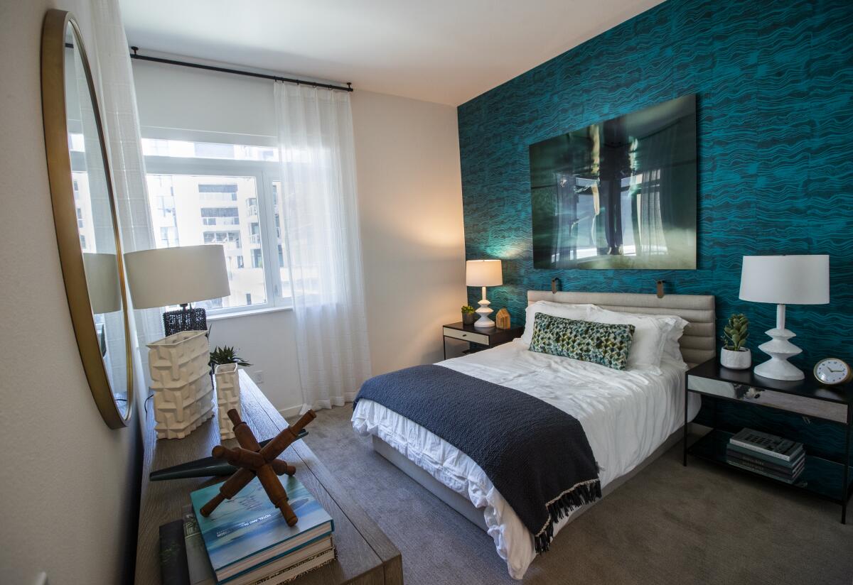 A tidy bedroom with a teal accent wall 