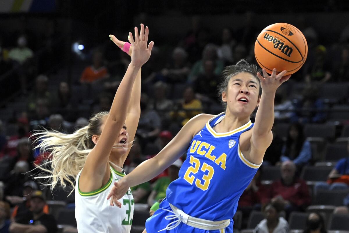 UCLA guard Natalie Chou shoots against Oregon guard Sydney Parrish.