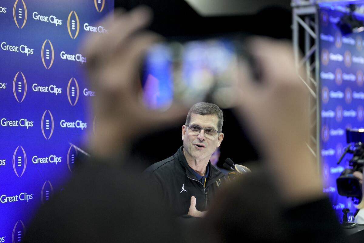 Michigan coach Jim Harbaugh speaks during a news conference in Houston.