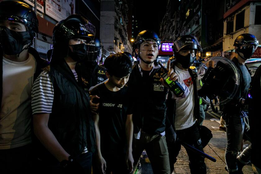 HONG KONG, CHINA -- MONDAY, SEPTEMBER 23, 2019: A 14 year old boy who shouted his name, Chiu Ho Chung, 14, is detained by police officers in riot gear near the Mong Kok police department in Hong Kong, on Sept. 23, 2019. (Marcus Yam / Los Angeles Times)