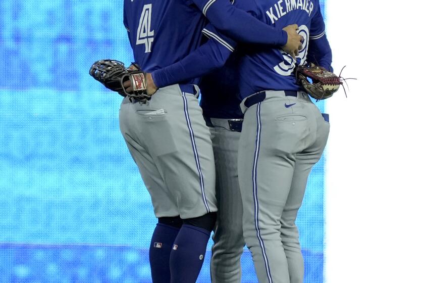 Los jardineros de los Azulejos de Toronto, Daulton Varsho, centro, Kevin Kiermaier, derecha, y George Springer (4) celebran después de su juego de béisbol contra los Reales de Kansas City, el lunes 22 de abril de 2024, en Kansas City, Missouri. Los Azulejos ganaron 5-3. (AP Foto/Charlie Riedel)