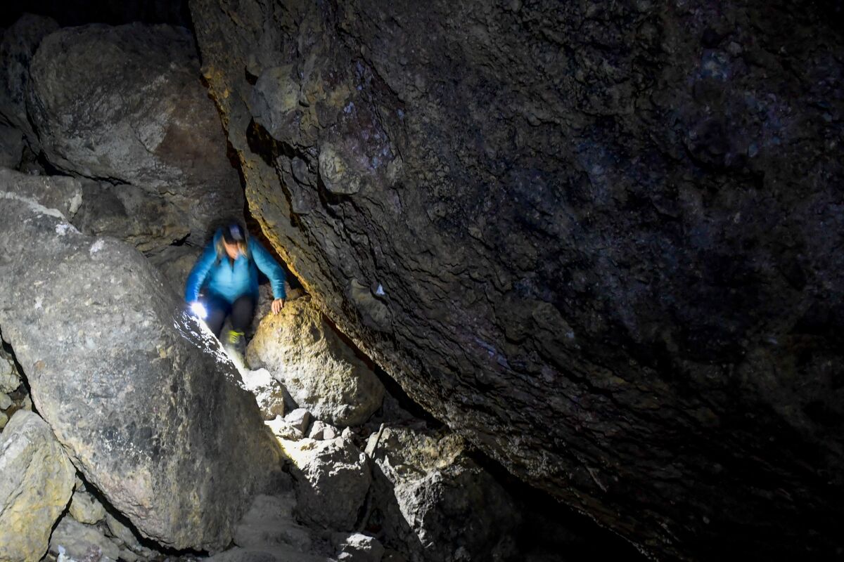 A person climbing inside a cave