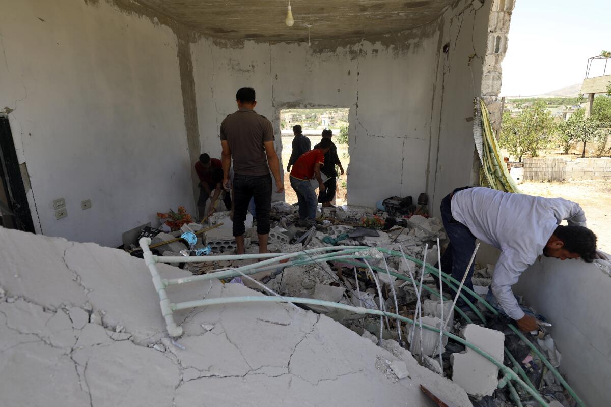 People inspect a damage house after shelling hit the town