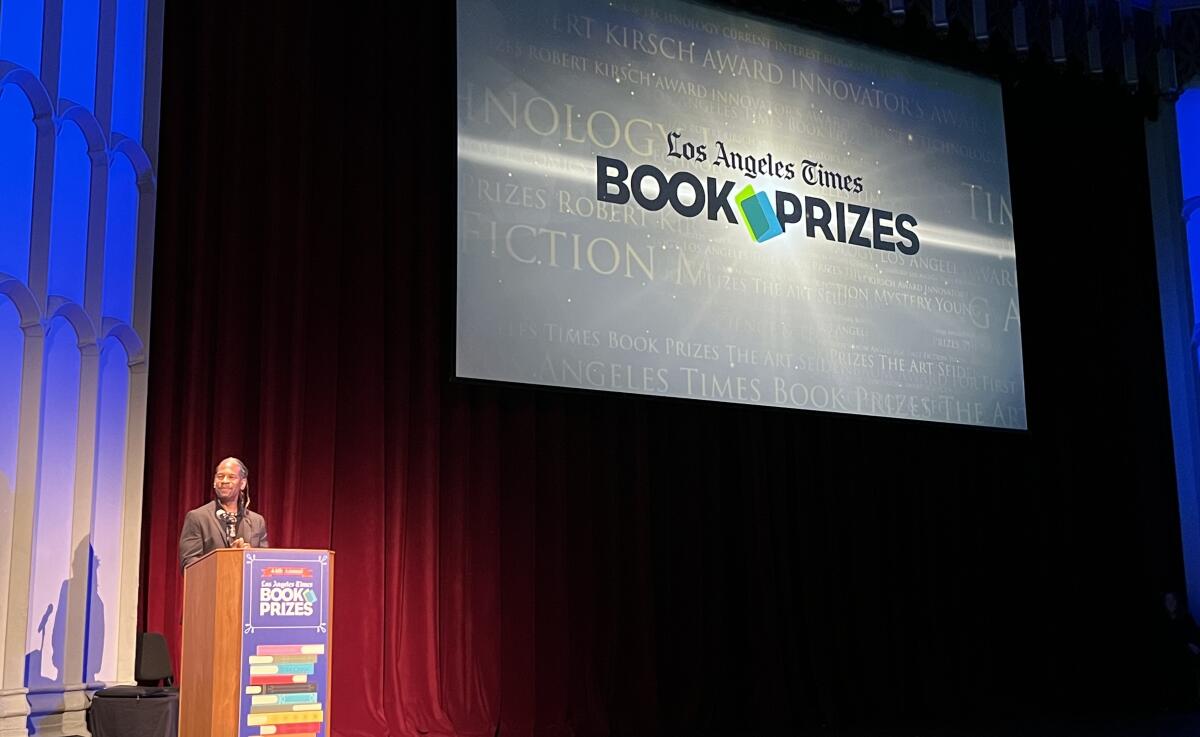 LZ Granderson stands at a lectern backed by a giant screen that says "Los Angeles Times Book Prizes."